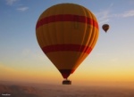 Close up image of hot air balloon floating with another hot air balloon in the distance