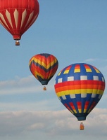 three hot air balloons floating in the sky